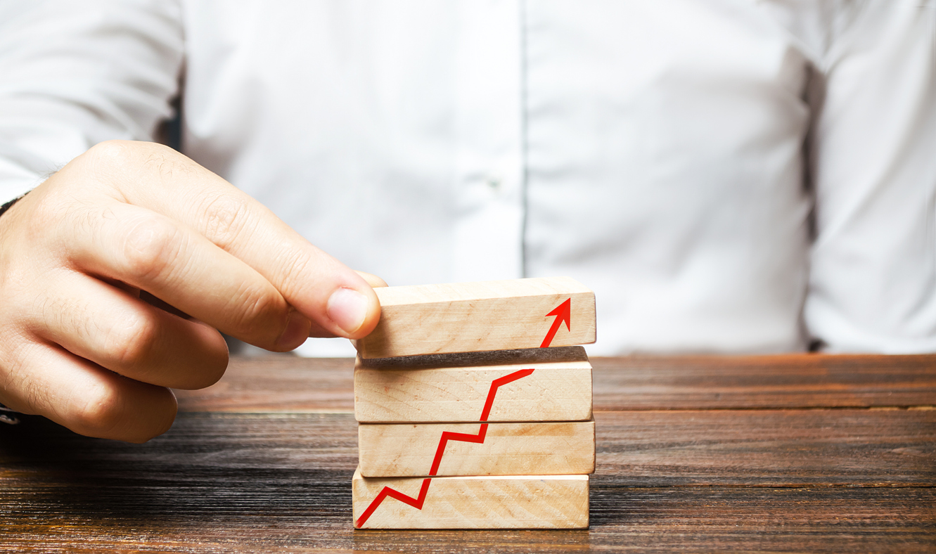 A man is putting together blocks with a red arrow chart. Build a business and increase profits, achieve success. Strategy and tactics. The concept of improving performance. Productivity and production Cómo impulsar el ahorro con la gestión de categorías