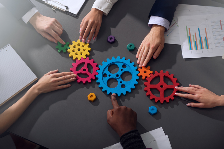 Business team connect pieces of gears. Teamwork, partnership and integration concept Gestión de los gastos indirectos: 6 retos causados por la falta de transparencia y cómo superarlos