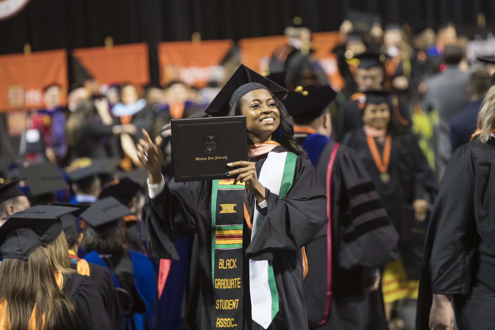 OSU student holding diploma at graduation