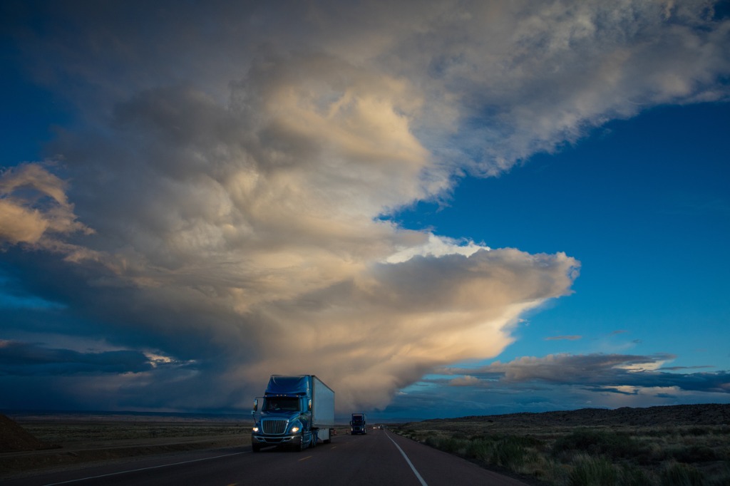 Motrex Drives Better Transportation Deals with Sourcing Optimizer - Blue Truck Driving at Twilight Through Southwest USA