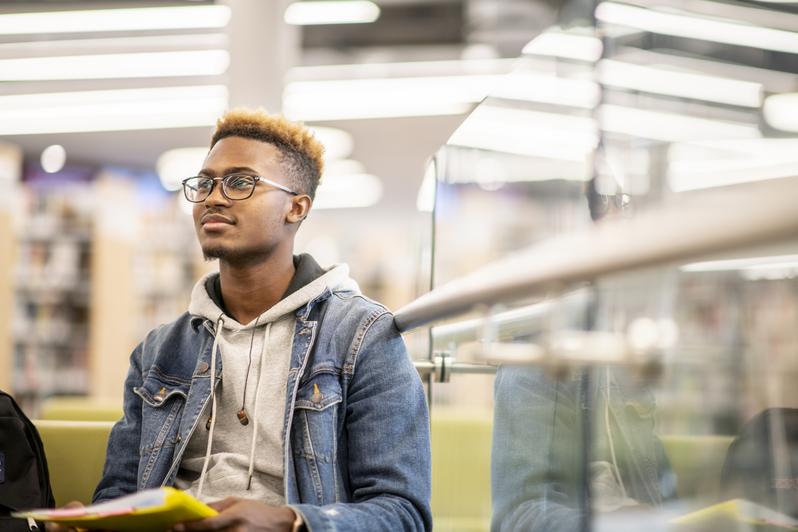 University student holding books in the library