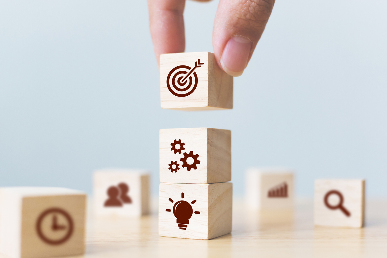 Concept of business strategy and action plan. Businessman hand putting wood cube block on top with icon Hindernisse überwinden: Category Management in der Beschaffungsbasis