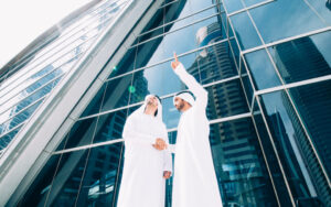 Arab businessmen in traditional clothes in front of modern building
